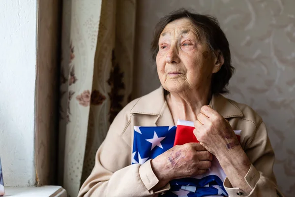 미국 국기를 집에 놓고 앉아 있는 나이든 여자 — 스톡 사진