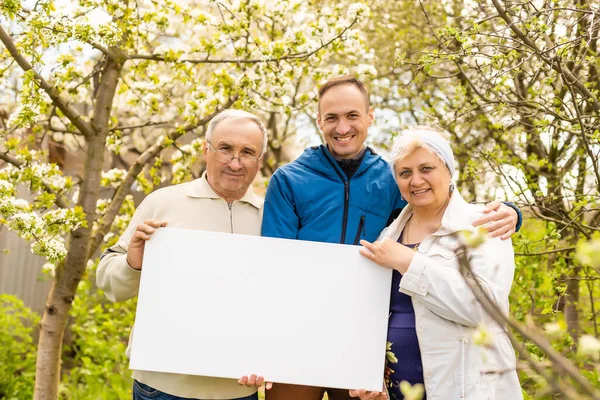 Familie hält Fotoleinwand im Garten — Stockfoto