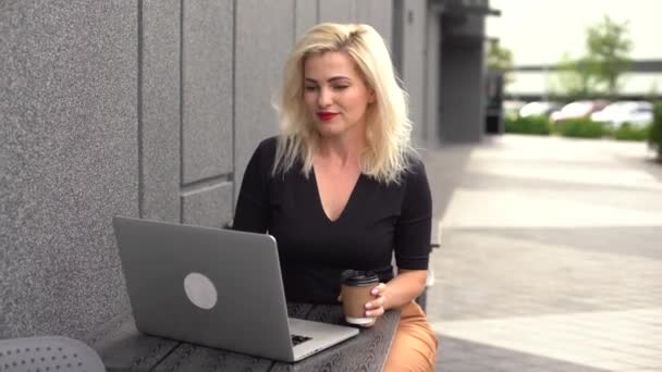Młoda biznesmenka pracująca przy komputerze w kawiarni. Młoda dziewczyna zmiennokształtna pracująca w laptopie, dzień pracy. — Wideo stockowe