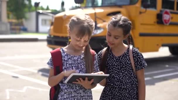 Onderwijs: Lachende studentenvrienden klaar voor school naast schoolbus — Stockvideo