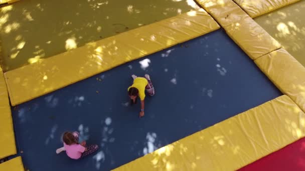 Chicas lindas divirtiéndose al aire libre. Saltar sobre trampolín en zona infantil. Parque de atracciones — Vídeos de Stock