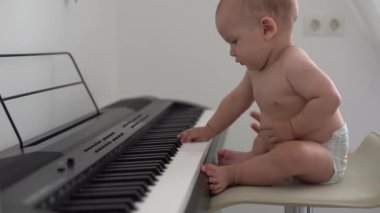 Küçük çocuk, evde piyano çalıyor, çocuk öğreniyor.