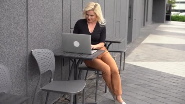 Jonge zakenvrouw werkt achter de computer in café. Jong meisje downshifter werken op een laptop, werkdag. — Stockvideo