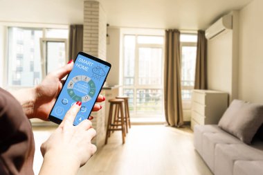 Akıllı telefonlu güzel bir kadın ekrana dokunuyor ve uygulama kullanıyor