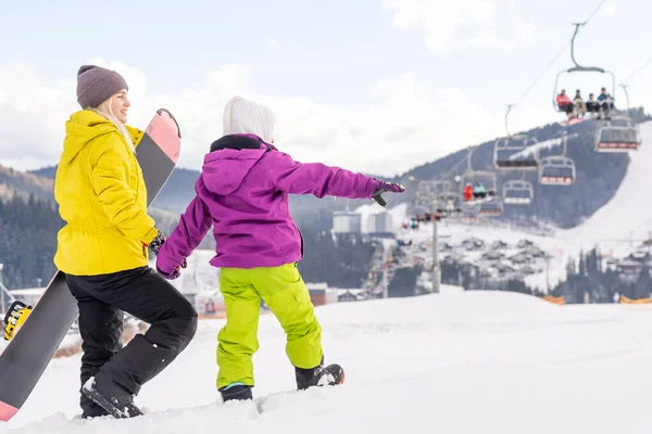 Mère et fille avec des snowboards jouent dans la neige — Photo