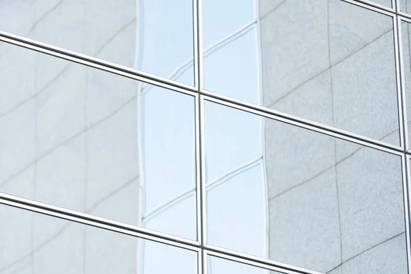 Perspective and underside angle view to textured background of modern glass building skyscrapers over blue cloudy sky — Stock Photo, Image