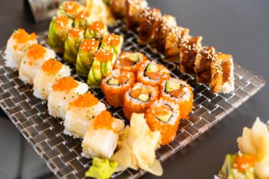 Somon ile Suşi rulo Philadelphia, füme eel, avokado, siyah arka plan üzerinde krem peynir. Suşi menüsü. Japon yemekleri.