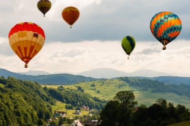Sıcak hava balonuyla orman dağının üzerinde gün batımı