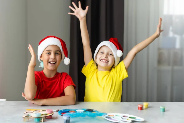 İki küçük kız kardeş Noel 'de evde el sanatları yaparken eğleniyorlar. — Stok fotoğraf