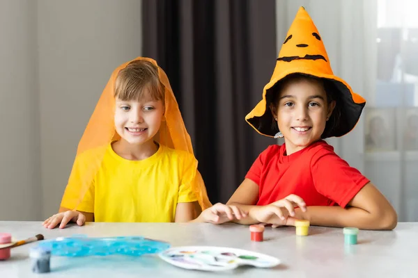 Humor de Halloween. dos niñas se están preparando para la fiesta, cortando decoraciones, haciendo hojas de otoño — Foto de Stock