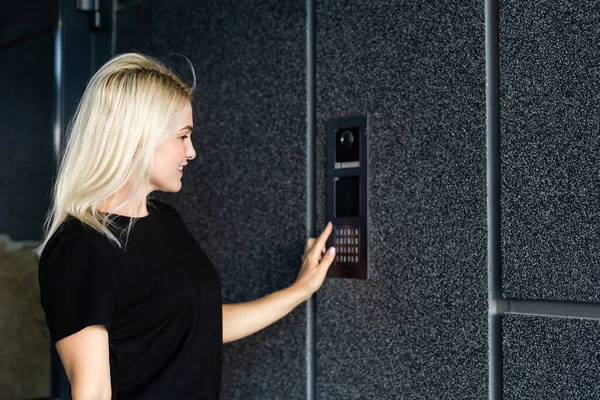 Γυναίκα κλήση ενδοεπικοινωνίας για να εισέλθουν σε ένα κτίριο — Φωτογραφία Αρχείου