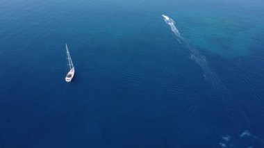 Parasailing, Parasailing Bir Teknenin Arkasında. Adam bir paraşütle denizin üzerinde uçuyor. Dağın arka planındaki tekneye bir ip bağlıyor.