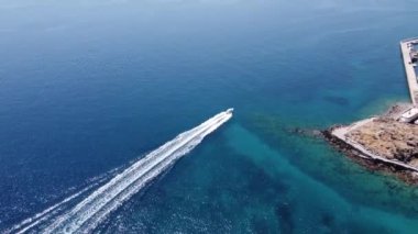 Parasailing, Parasailing Bir Teknenin Arkasında. Adam bir paraşütle denizin üzerinde uçuyor. Dağın arka planındaki tekneye bir ip bağlıyor.