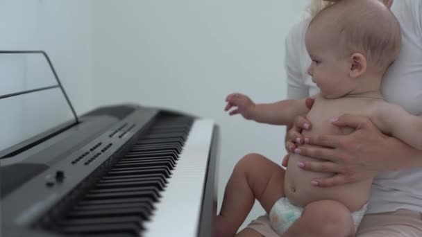 Anne ve küçük çocuk, evde piyano çalıyor, çocuk öğreniyor. — Stok video