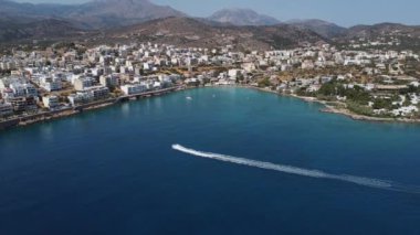 Parasailing, Parasailing Bir Teknenin Arkasında. Adam bir paraşütle denizin üzerinde uçuyor. Dağın arka planındaki tekneye bir ip bağlıyor.