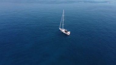 Parasailing, Parasailing Bir Teknenin Arkasında. Adam bir paraşütle denizin üzerinde uçuyor. Dağın arka planındaki tekneye bir ip bağlıyor.