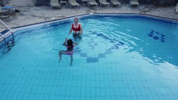 Mother and daughter playing in a swimming pool — Stock Video