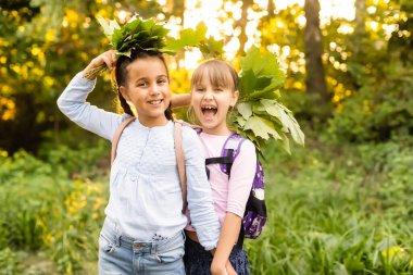 Güneşli bir sonbahar gününde bir parkta birlikte poz iki sevimli gülümseyen 8 yaşındaki kız. Dostluk kavramı.