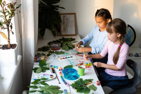 Duas alunas desenhar folhas, meninas pintar folhas de outono — Fotografia de Stock