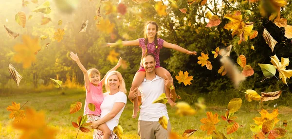 Imagen de la encantadora familia en el parque de otoño, padres jóvenes con niños adorables jugando al aire libre, cinco personas alegres se divierten en el patio trasero en otoño, la familia feliz disfruta de la naturaleza otoñal — Foto de Stock