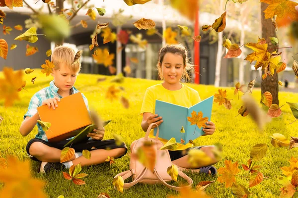 Kinderen lezen een boek in de herfst — Stockfoto