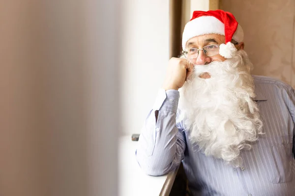 Porträt eines älteren Mannes mit Weihnachtsmütze, der in die Kamera blickt — Stockfoto