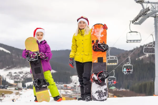 Família em santa chapéus e snowboards — Fotografia de Stock