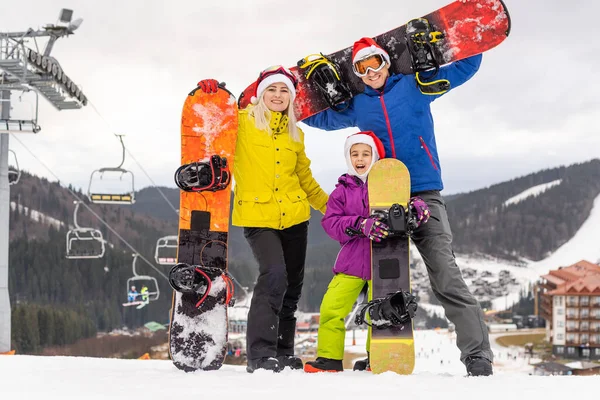 Famille dans santa chapeaux et snowboards — Photo