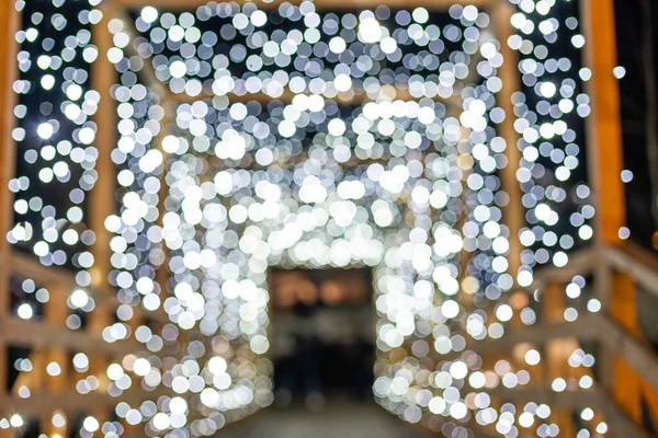 Fundo escuro embaçado festivo com luzes bokeh, guirlanda elétrica e casa — Fotografia de Stock