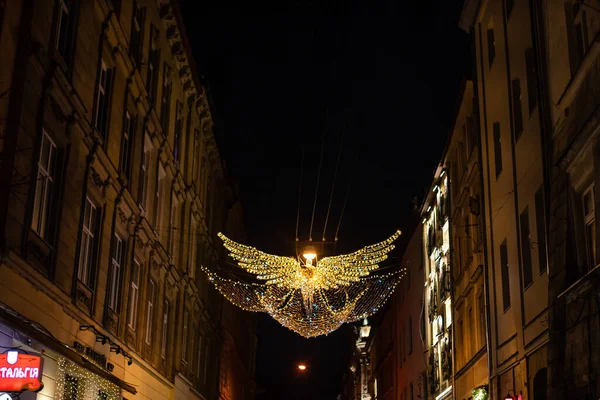 LVIV, UCRÂNIA - 29 DE DEZEMBRO DE 2020: guirlandas no fundo do céu noturno sob a forma de um anjo. — Fotografia de Stock