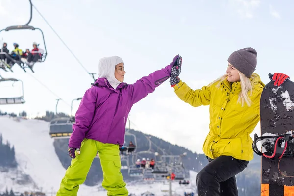 Moeder en dochter met snowboards spelen in de sneeuw — Stockfoto