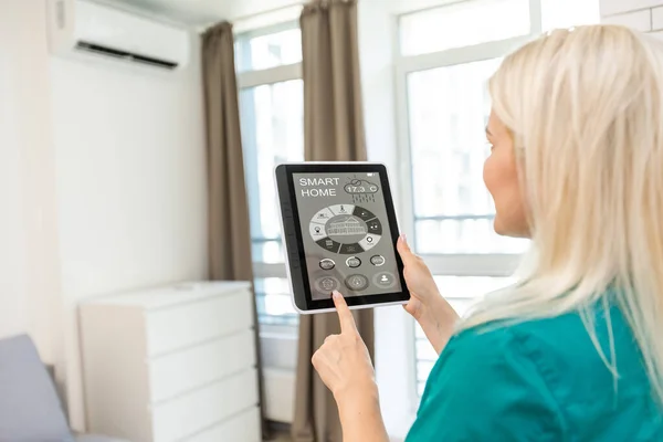 Mulher em casa usando tela inteligente, sistema doméstico de automação — Fotografia de Stock
