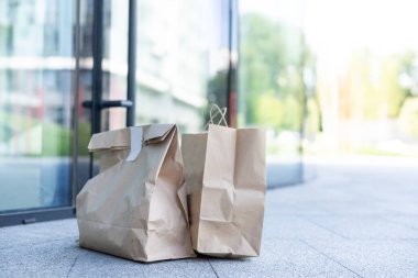 Evin kapısının yanında bir kese kağıdı var. Güvenli teslimat konsepti. Temassız ev yemeği teslimatı. İhtiyati tedbirler.