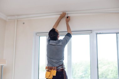 Adam perdeler için korse topluyor.