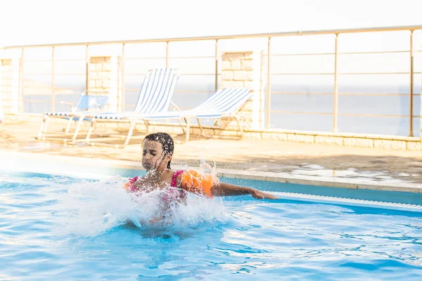 Jolie petite fille nageant dans la piscine extérieure et s'amuser — Photo