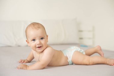 Beyaz güneşli yatak odasında sevimli bir erkek bebek. Yeni doğmuş çocuk yatakta dinleniyor. Küçük çocuklar için çocuk odası. Aile sabahı evde. Yeni doğan çocuk