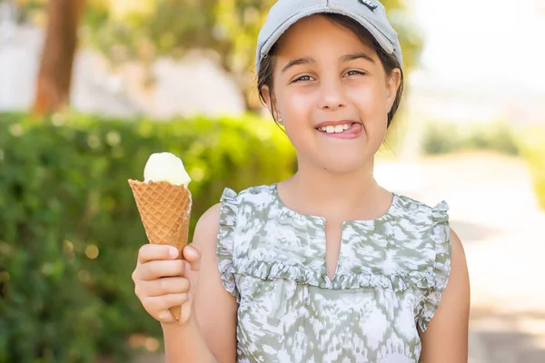 White ice cream in hand of beautiful little girl