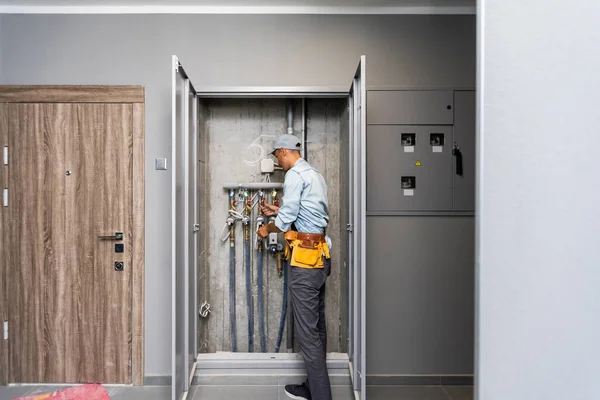 Klempner repariert Wasserleitungen in Wohnhaus — Stockfoto