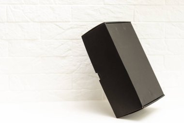 Beyaz arkaplanda siyah hediye kutusu.