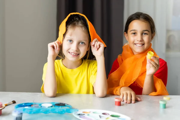 Zwei kleine Mädchen basteln aus Herbstblättern für Halloween zu Hause — Stockfoto