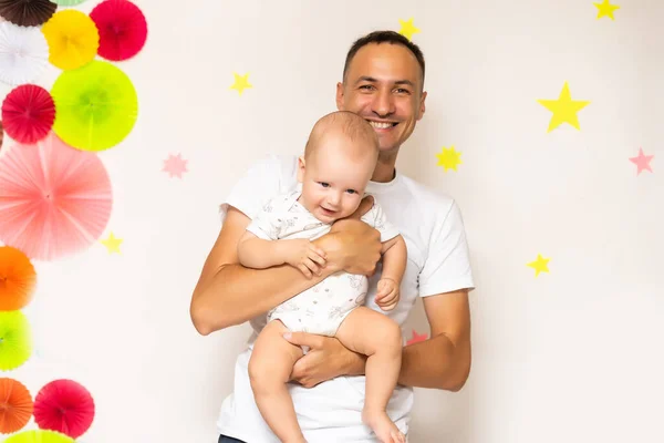 Smiling young mother and father standing at home cradling the cute baby girl in their arms — Stock Photo, Image