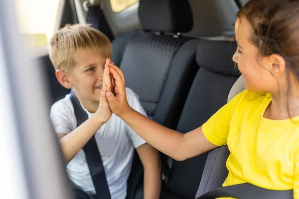 Leende barn sitter på baksätet i bilen — Stockfoto