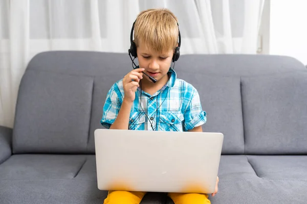 De kleine jongen met laptop thuis. — Stockfoto