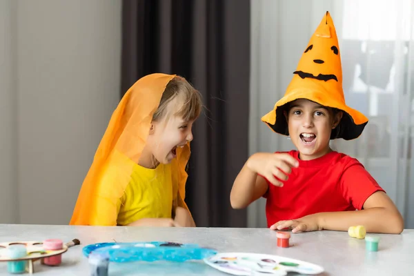 Halloween nastrój. dwie małe dziewczynki przygotowują się do przyjęcia, wycinając dekoracje, robiąc jesienne liście — Zdjęcie stockowe