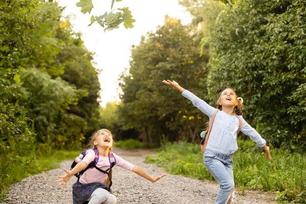 Zwei süße lächelnde 8-jährige Mädchen posieren an einem sonnigen Herbsttag gemeinsam in einem Park. Freundschaftskonzept. — Stockfoto