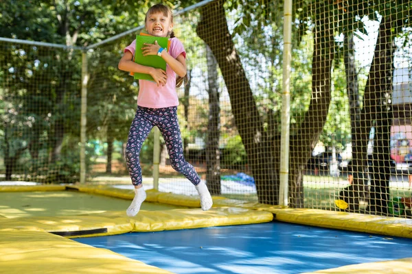 Dziewczyna z książkami skakać na trampolinie — Zdjęcie stockowe