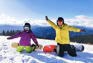 Dağlarda kış tatili yapan snowboardcu ailesi.