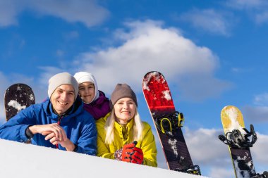 Kışın snowboard yapan bir aile.