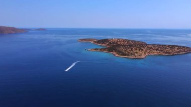 Mavi berrak sularda bir teknenin drone görüntüsü. Mavi denize giden beyaz bir teknenin üst görüntüsü. Büyük sürat teknesi yüksek hızda hareket ediyor. Seyahat - resim