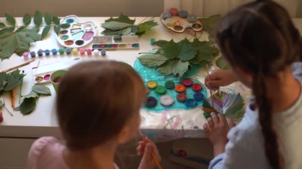 여학생 두 명 이 나뭇잎을 그리고 여학생들은 가을 나뭇잎을 색칠하고 — 비디오